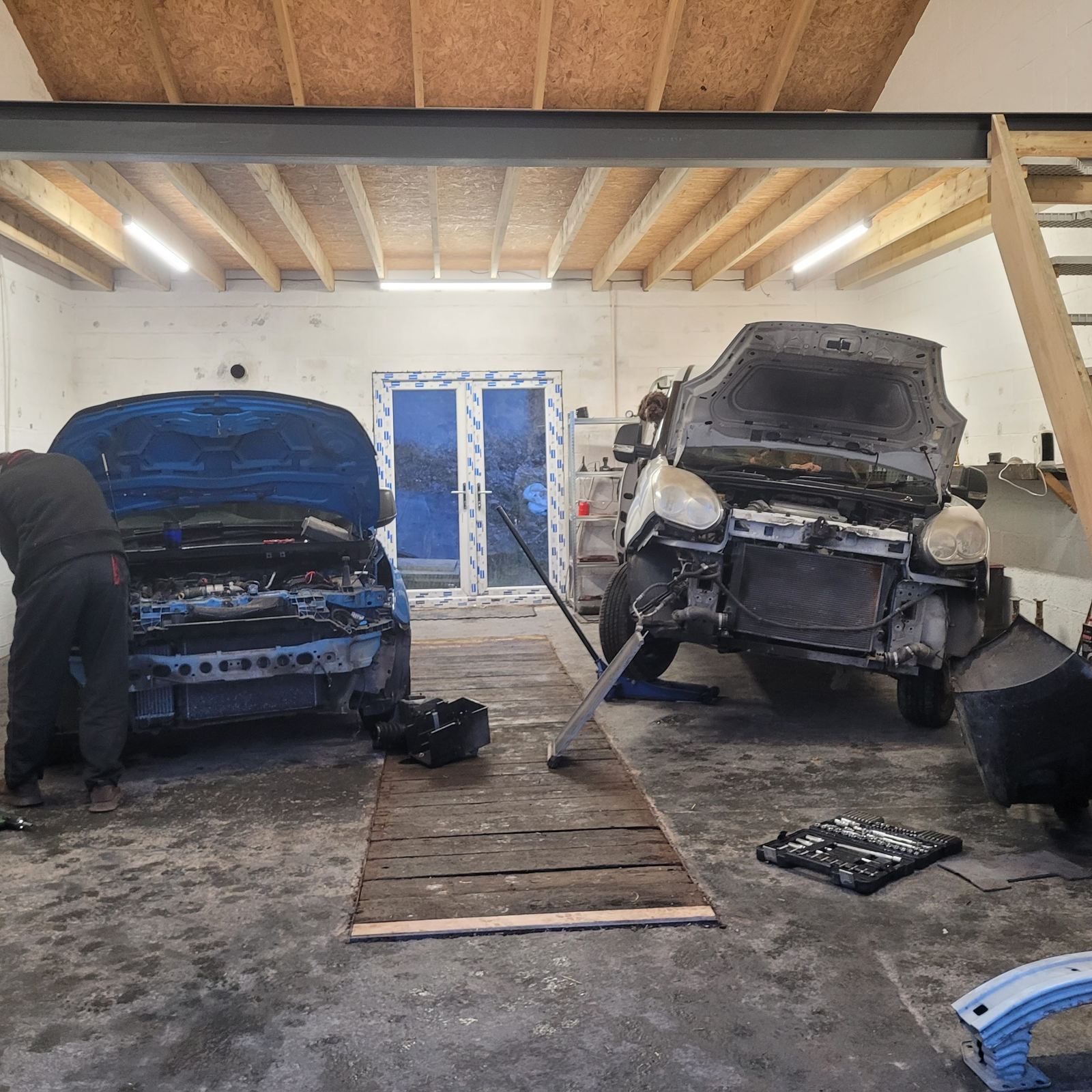 Inside the Davies & Sons workshop in Pencader with two cars being repaired