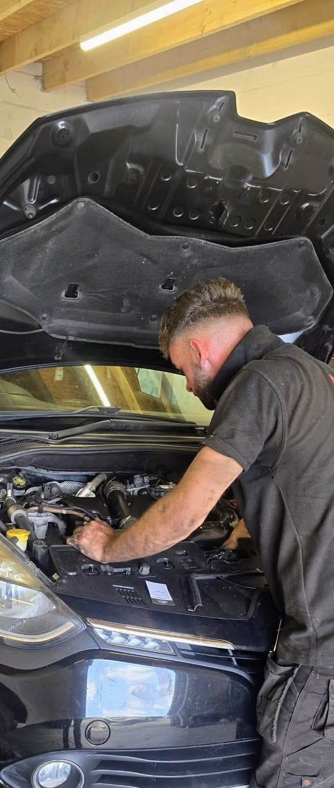 Mechanic checking the engine of a black car