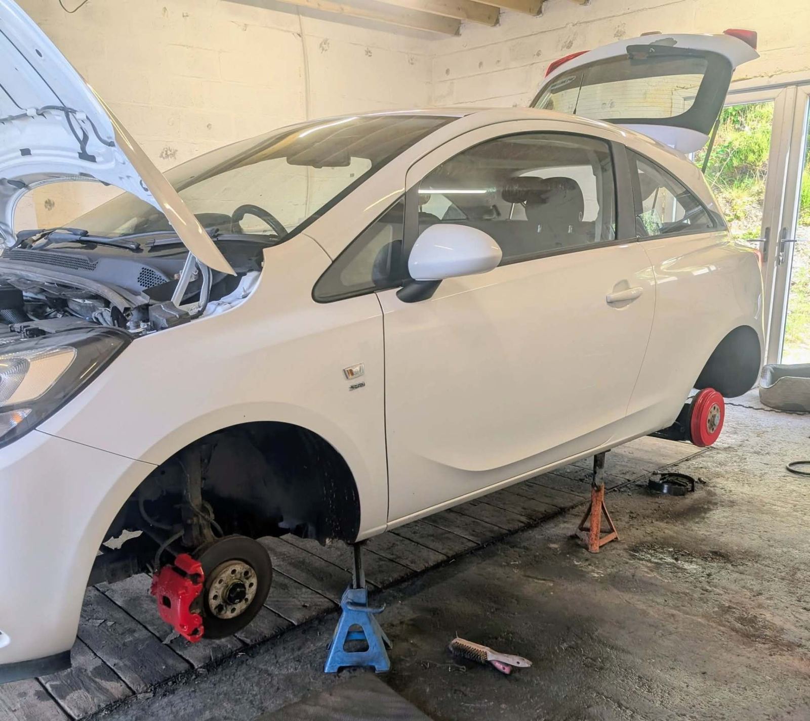 Brake work on a white car raised on axle stands
