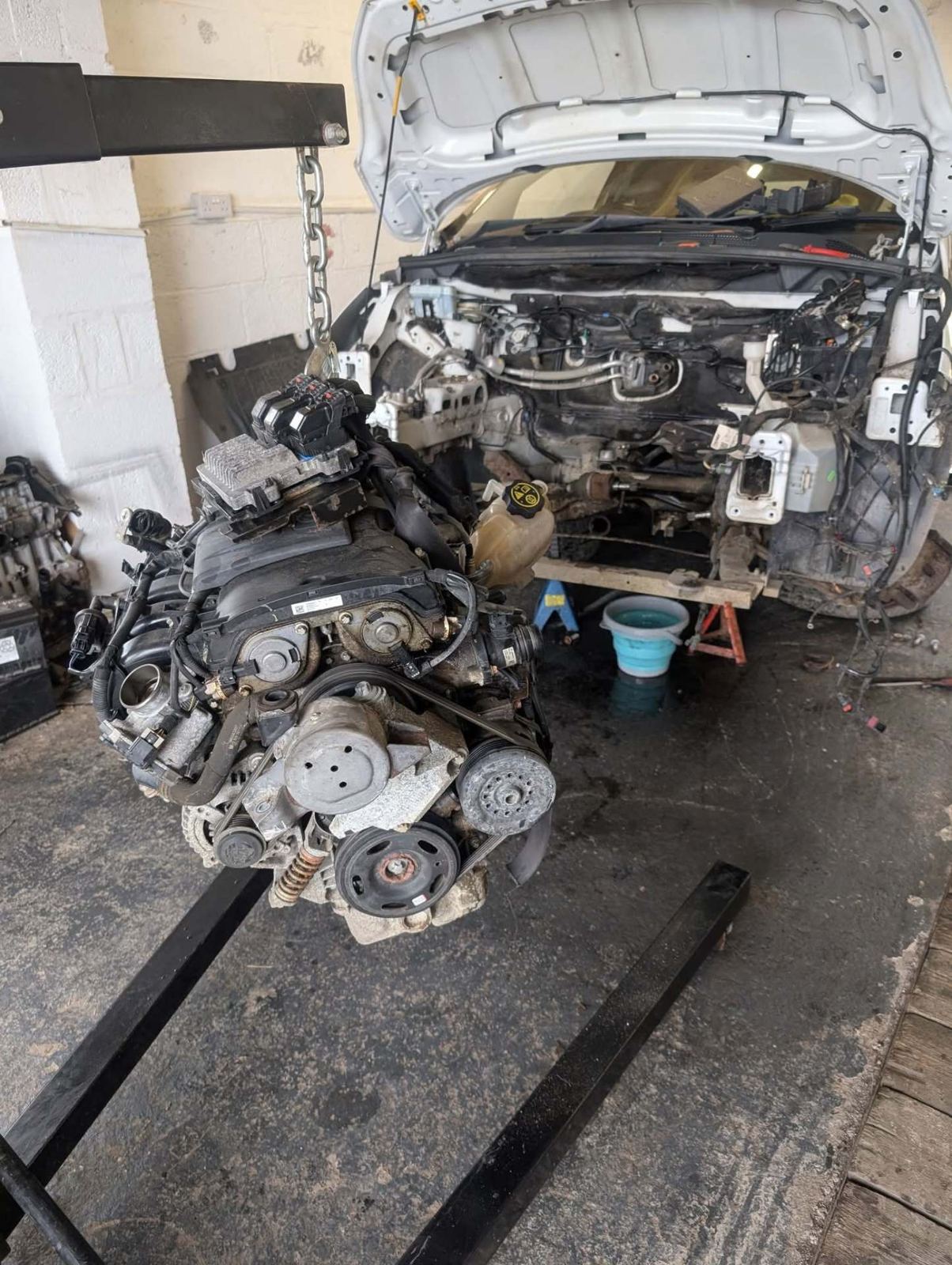 Engine lifted out of a van on an engine crane